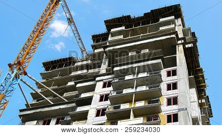 Construction Builsing Against Blue Sky. Crane Near Building. Construction Site.