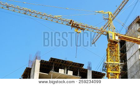 Crane. Construction Crane. Building Crane On The Background Of Two Buildings.