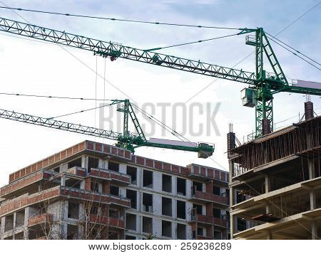 Construction Site Background. Two Cranes Near Building Under Construction