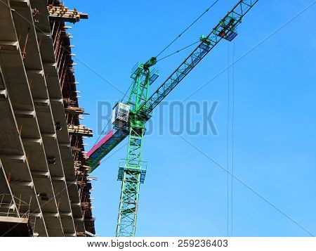 Crane. Construction Crane. Huge And Building On The Background Of The Blue Sky