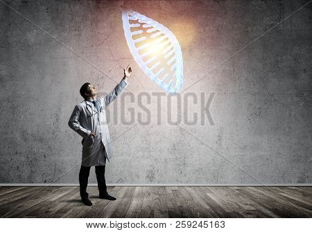 Conceptual Image Of Successful And Young Doctor In White Uniform Interracting With Dna Structure Whi