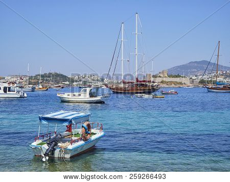 Bodrum, Turkey - July 5, 2018. Boats Moored At Kumbahce Bay With The Castle Of Saint Peter In The Ba