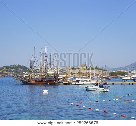 Bodrum, Turkey - July 5, 2018. Sailboats And Yachts Moored At Kumbahce Bay With The Castle Of Saint 
