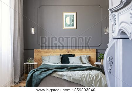 Graphic On The Wall Decorated With Molding In A Bedroom Interior With A Double Bed With Pillows And