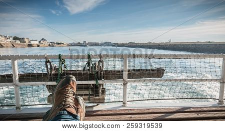 relaxed man sitting at the back of a ferry leaving the port towards Yeu Island