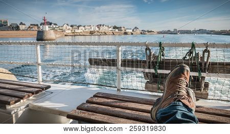 Relaxed Man Sitting At The Back Of A Ferry Leaving The Port Towards Yeu Island