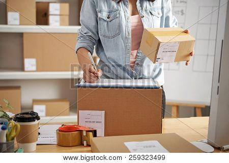 Young Postwoman Working With Orders And Parcels At Post Office