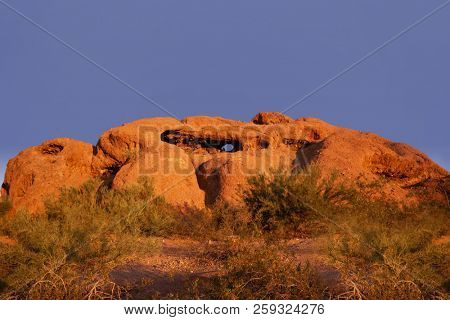 Papago Park known as the hole in the rock glowing red orange as sunsets over Phoenix,Arizona,USA