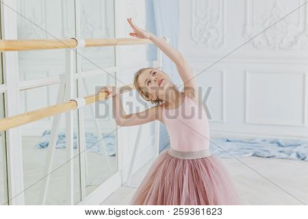 Young Classical Ballet Dancer Girl In Dance Class. Beautiful Graceful Ballerina Practice Ballet Posi