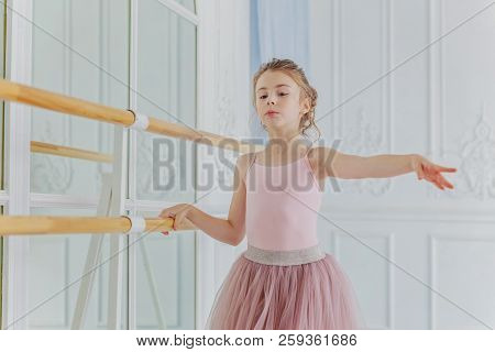 Young Classical Ballet Dancer Girl In Dance Class. Beautiful Graceful Ballerina Practice Ballet Posi