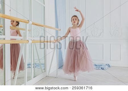 Young Classical Ballet Dancer Girl In Dance Class. Beautiful Graceful Ballerina Practice Ballet Posi