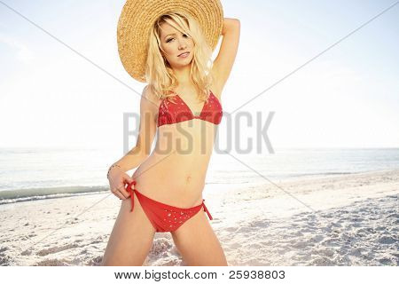 Sexyl girl on the beach in red bikini. Shoot against sun.