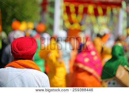 Sikh Man With Red Turban During An Outdoor Parade And More People