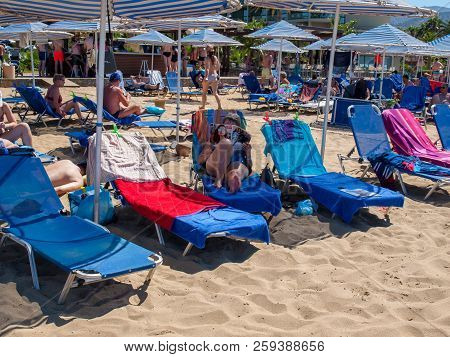 Malia, Crete, Greece - July 1, 2018: People Are Resting On A Sunny Day At The Beach In Malia, Crete,