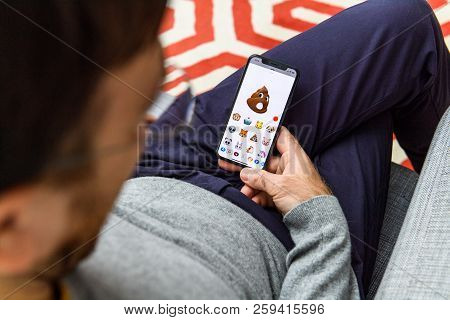 London, Uk - Sep 21, 2018: Man Using The New Pile Of Poo Ar Memoji Emoji Face On Apple Iphone Xs Wit