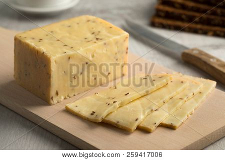 Piece of traditional German caraway cheese and slices