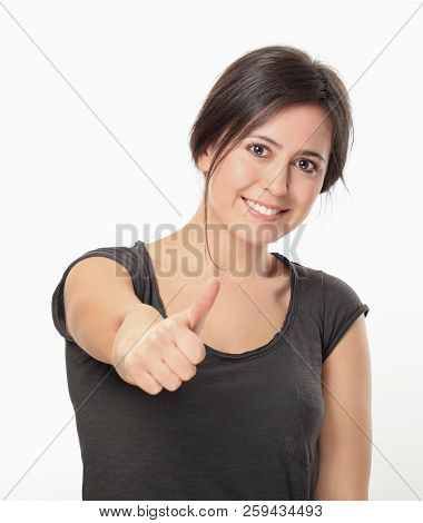 Young Woman Thumbs Up Against White Wall