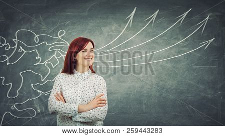 Concept Of Information Processing As A Concentrated Redhead Woman Smiling In Front Of A Huge Blackbo