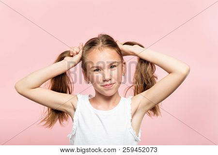 Happy Joyful Smiling Adolescent Girl Making Pig Tails From Her Hair. Relaxed Carefree Lifestyle And 