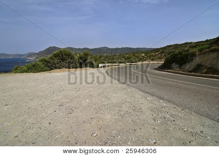 Strada vicino al mare nelle montagne della Sardegna. Italia.