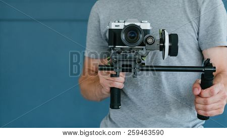 Video Content Creation Process. Man Holding Camera And Shooting Footage For Blog Or Broadcasting. Pr