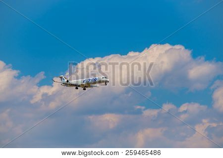Zurich, Switzerland - July 19, 2018: Adria airlines airplane flying in the blue cloudy sky,  preparing for landing at day time in Zurich nternational airport