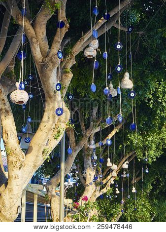 A Lot Of Nazar Boncugu, A Turkish Eye-shaped Amulet Hanging From The Branches Of A Tree. Turkey.