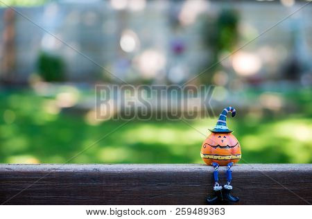 Little Pumpkin Head With A Witches Hat Sitting On A Fence Like Humpty Dumpty