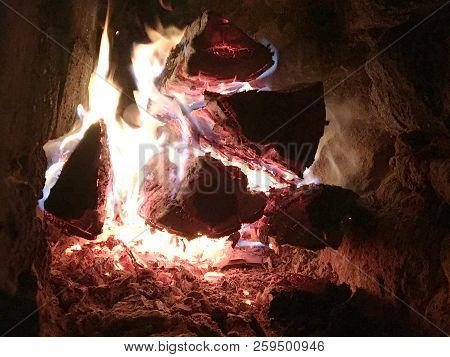 Beautiful Red Flame From Slice Wood, Dark Grey Black Coals Inside Metal Brazier. Wood Burning In The