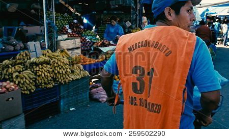 Santa Cruz, Bolivia - Sept 5 2018: Young Man Pushing A Wheelbarrow To Transport Vegetables At The Ci