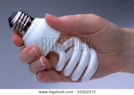 Mulher segurando uma lâmpada compacta fluorescente de baixa energia CFL