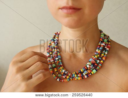 Bright Beads Of Murano Glass On A Young Girl. The Girl's Hand Touches The Beads