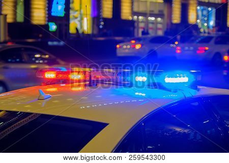 Red And Blue Flashing Lights On Police Car In The Night.