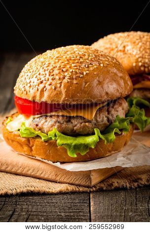 Close-up Photo Of Home Made Hamburger With Beer Made Of Beef, Onion, Tomato, Lettuce, Cheese And Spi