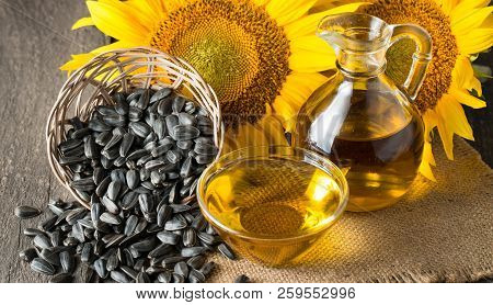 Sunflower Oil And Sunflower Seeds In Small Sack On Traditional Rustic Wooden Background. Organic And