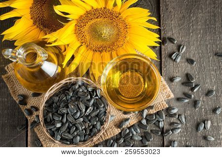 Sunflower Oil And Sunflower Seeds In Small Sack On Traditional Rustic Wooden Background. Organic And