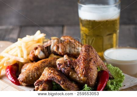Close-up Photo Of Bbq Chicken Wings With Fries And Beer. Barbeques Meat With Sauces, Ketchup, Mayonn