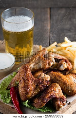 Close-up Photo Of Bbq Chicken Wings With Fries And Beer. Barbeques Meat With Sauces, Ketchup, Mayonn