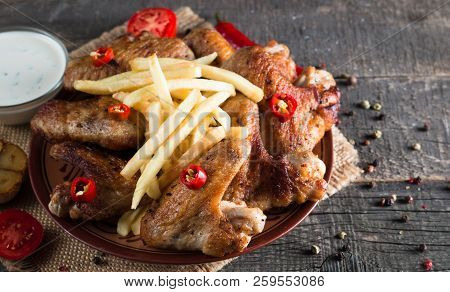 Close-up Photo Of Bbq Chicken Wings With Fries And Beer. Barbeques Meat With Sauces, Ketchup, Mayonn