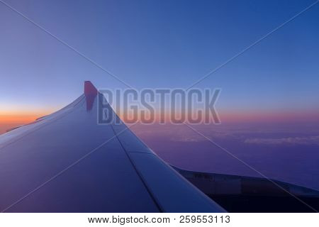 Wing Of The Airplane In Blue Skies At Sunset Background.