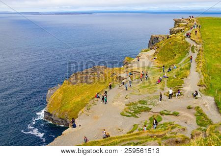 People Walking Over Cliffs Of Moher