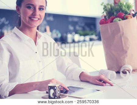 Young Woman Planning Expenses And Paying Bills On Her Kitchen