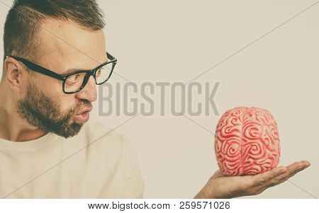 Adult Nerd Man Wearing Eyeglasses Looking At Human Brain Model. Thinking And Intelligence Conept