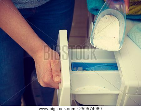 Washing Powder Detergent And Measuring Cup Pouring Into Machine. Household Duties, Clothes Laundry O