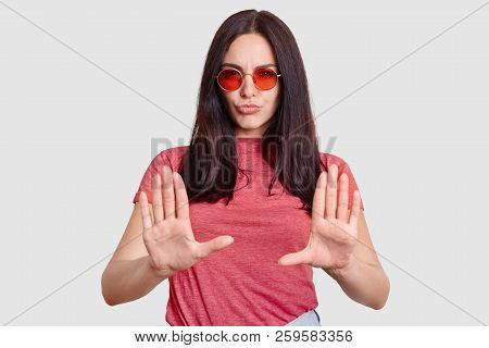 Fashionable Woman Being Dissatisfied With Something, Shows Refusal Gesture, Keeps Palms In Front, We