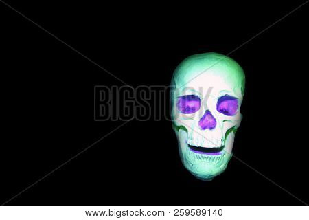 Glow in the dark painted skull. Ultraviolet glow in the dark paint. voodoo glow skull. luminescent glowing skull under black light.
