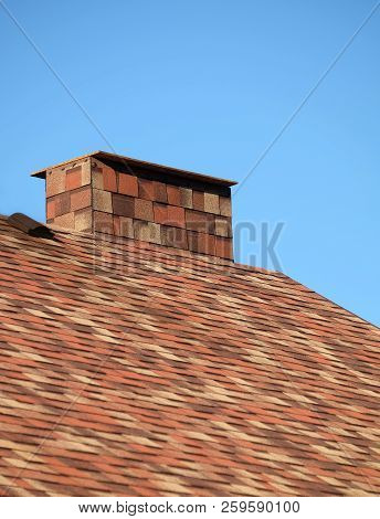 Part Of Brown Roof Of A House Covered With Motley Soft Shingles With Short Big Smokestack Close Up U