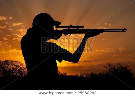 Silhouette di un giovane uomo con coda di cavallo riprese contro il cielo al tramonto drammatico