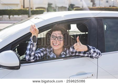 Young Woman In Car Shows Thumbs Up And Key