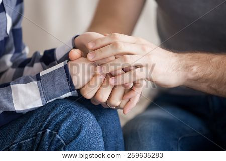 Close Up Of Couple Holding Hands Reconciled After Fight